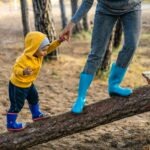 Child hand in hand with an adult walking up a balk