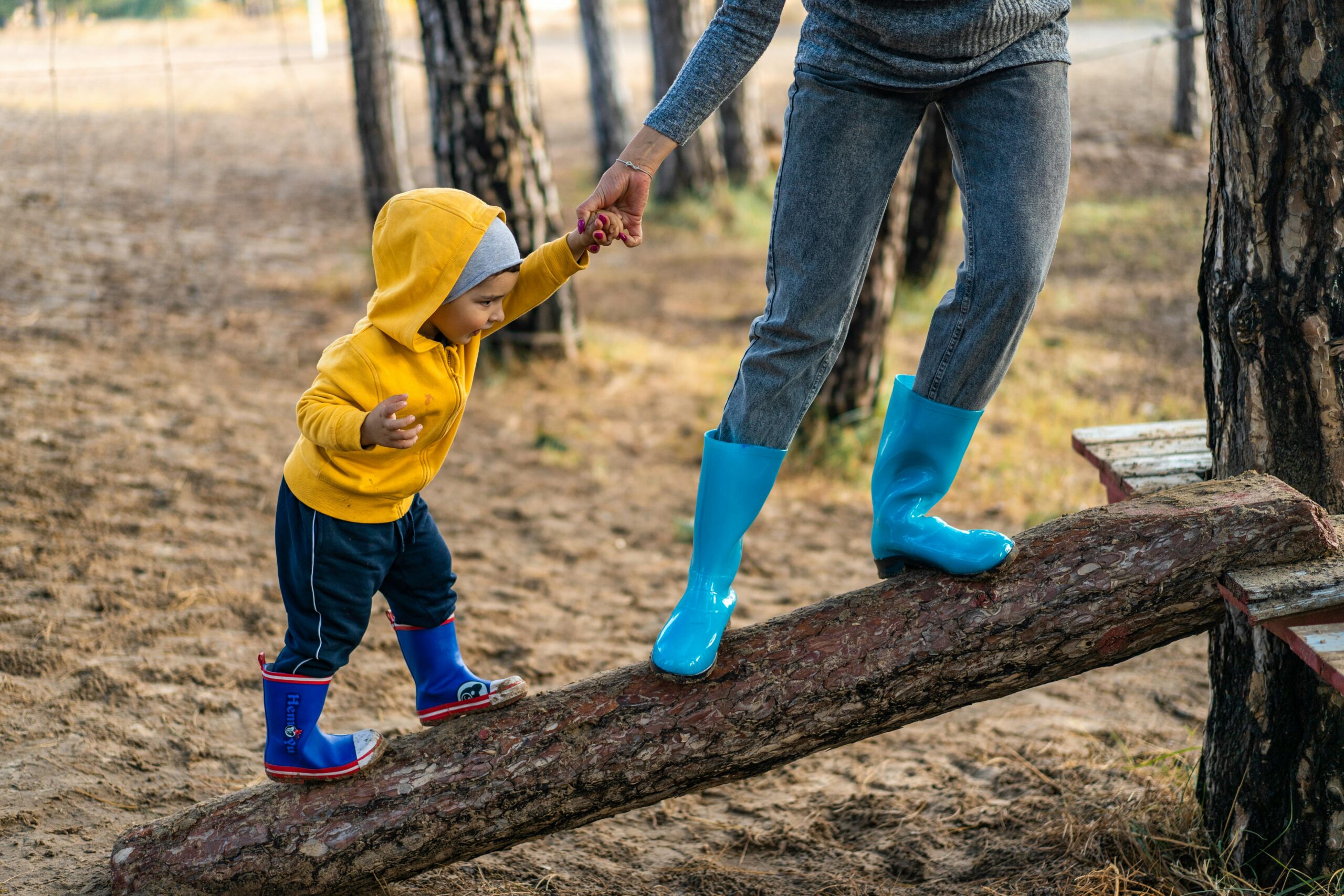 Child hand in hand with an adult walking up a balk