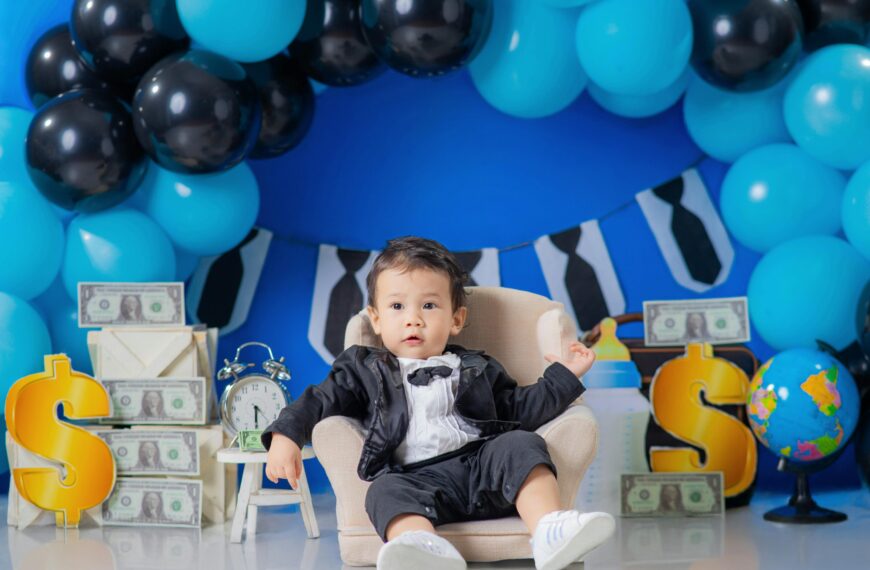 Child boy in armchair surrounded by money and balloons