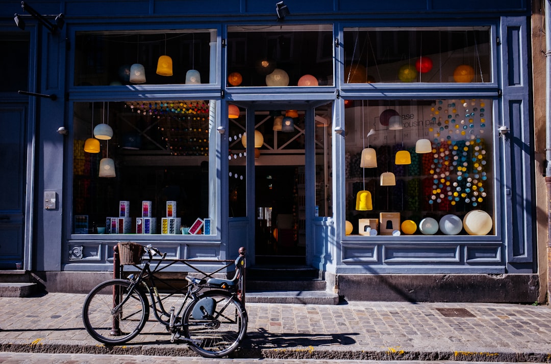 A shop front for a lamp shop – small and old-fashioned, with a bicycle parked in front, on the pavement