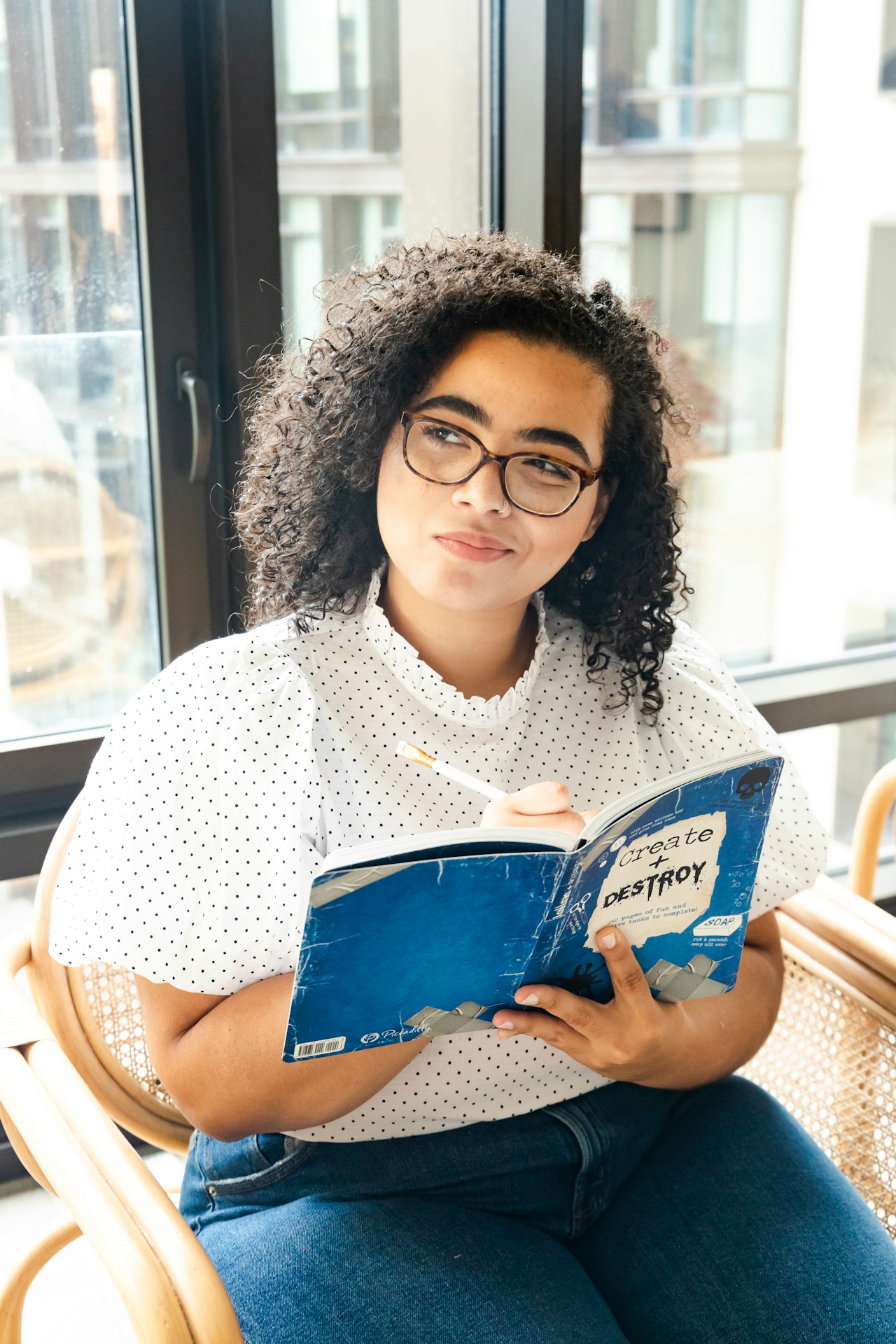 Woman reading a book, writing notes in it with a pencil