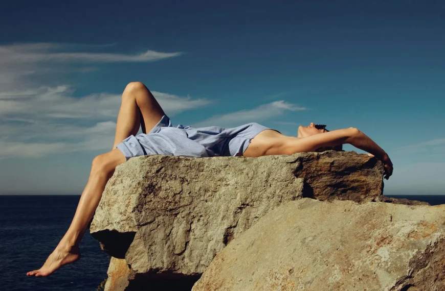 Woman lying on a rock in the sunshine, relaxing